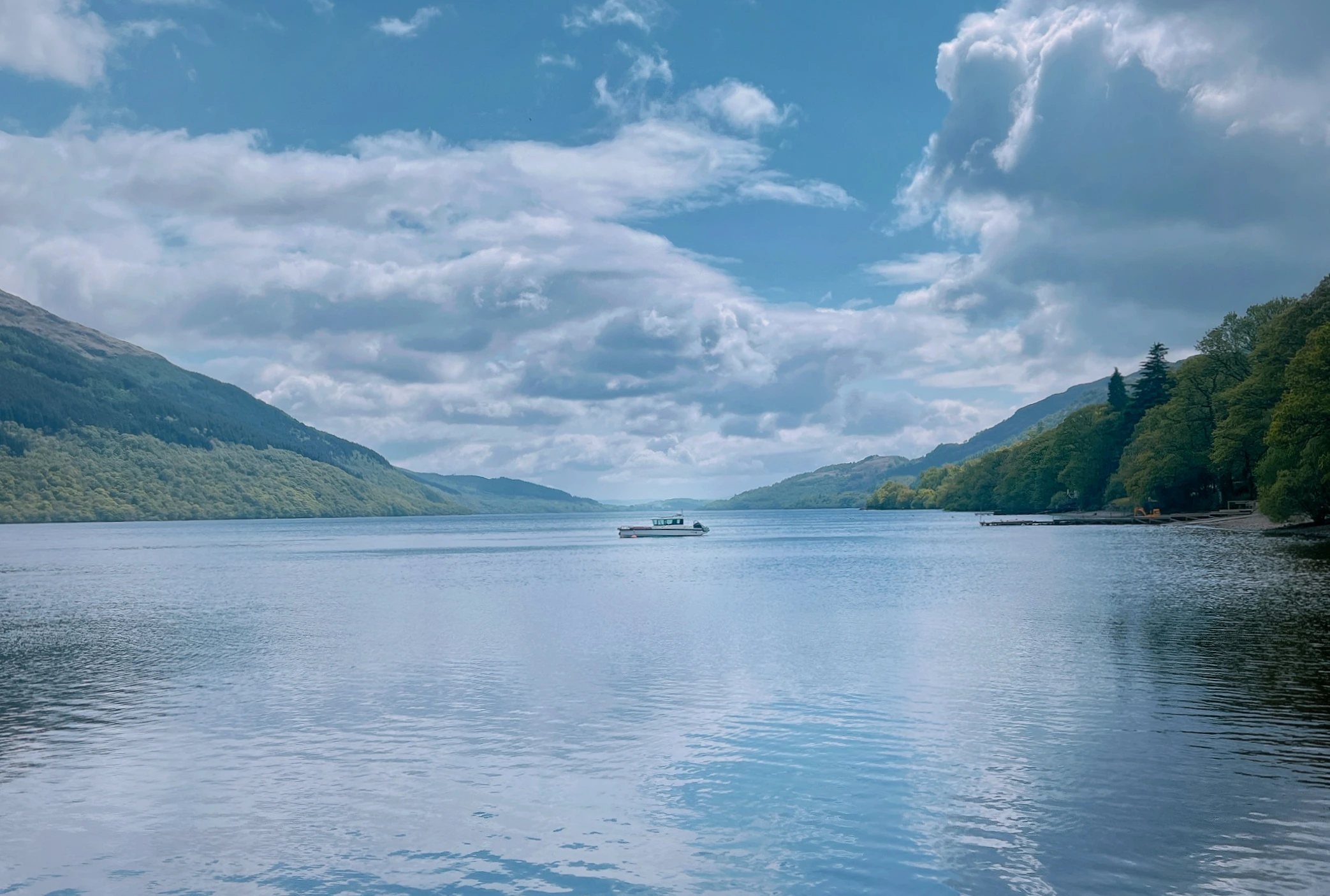 Boat on Loch Lomond beneath a bright sky